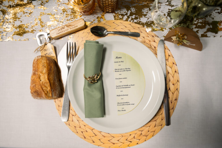 Photographe mariage Jura : assiette avec serviette vert sauge et menu personnalisé
