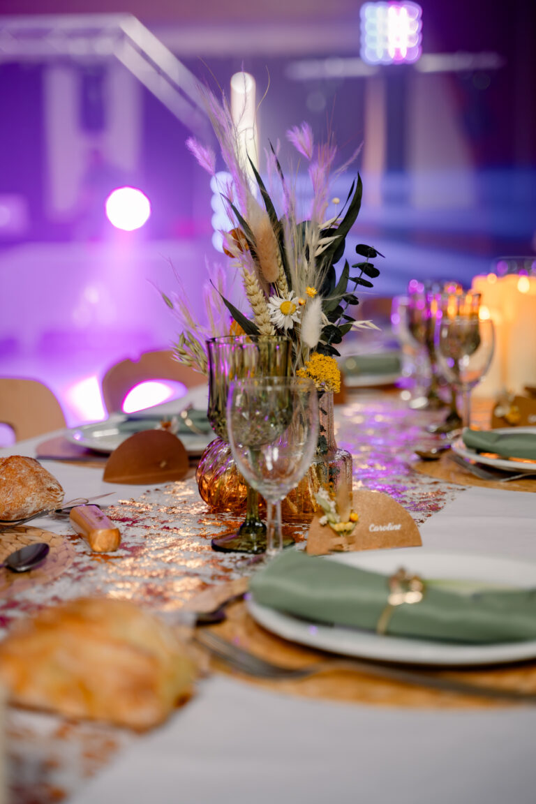 Photographe mariage Jura : centre de table de fleurs séchées sous les lumières de la soirée