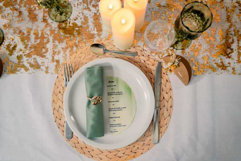 Photographe mariage Jura : assiette dressée avec serviette verte et sets en rotin