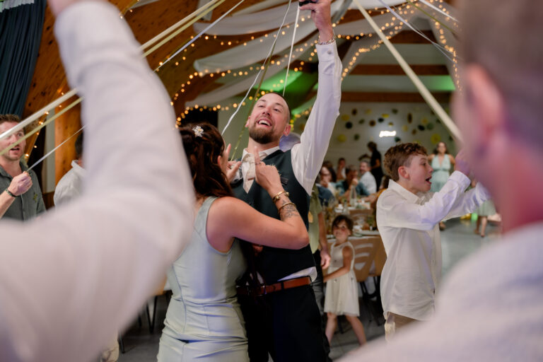 Photographe mariage Jura : invités qui lèvent les bras pour faire la fête