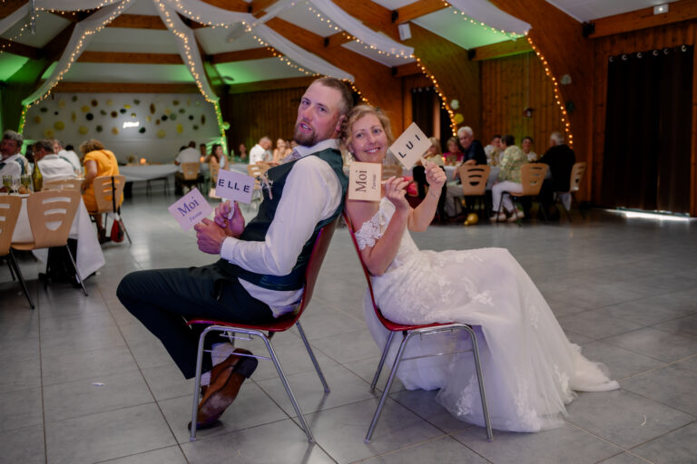 Photographe mariage Jura : mariés assis sur des chaises au milieu des invités
