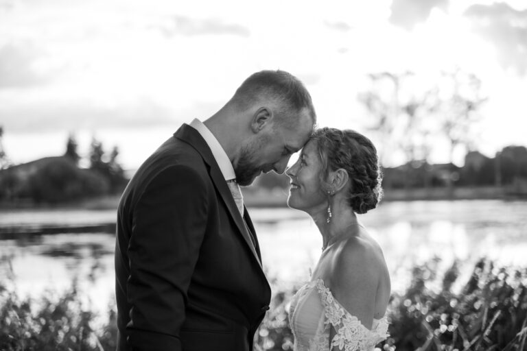 Photographe mariage Jura : mariés front contre front au bord de l’eau, en noir et blanc