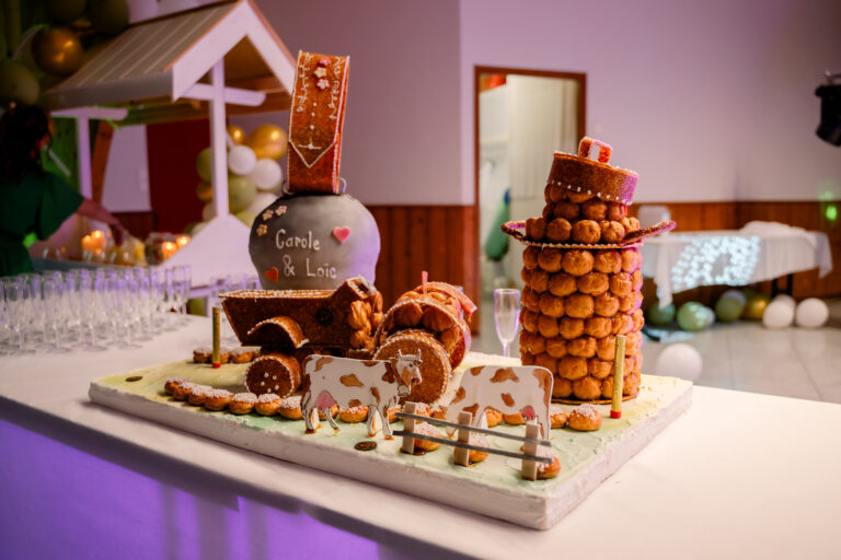 Photographe mariage Jura : buffet des desserts avec pièce montée et décor champêtre