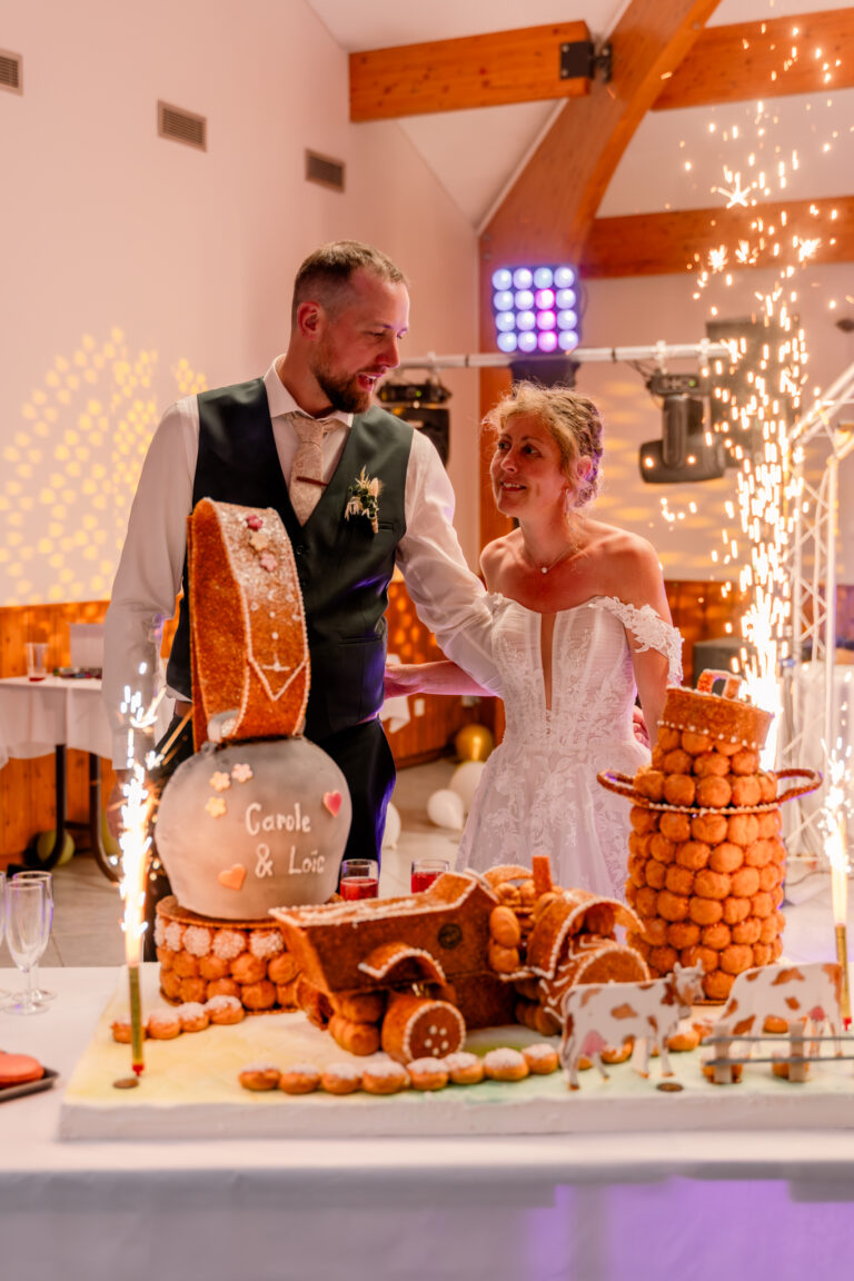 Photographe mariage Jura : mariés devant leur pièce montée et les fontaines lumineuses