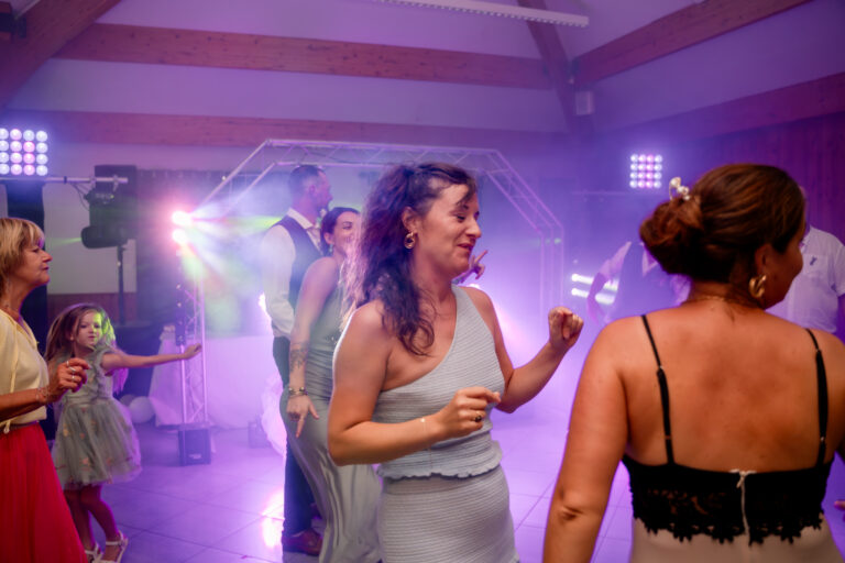 Photographe mariage Jura : invitées qui dansent sous les lumières colorées