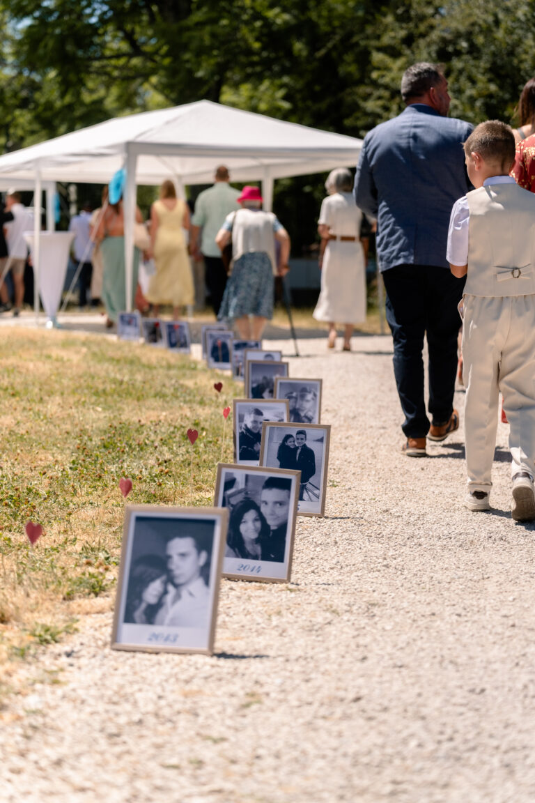 Photographe mariage Jura : allée de photos encadrées menant à la cérémonie