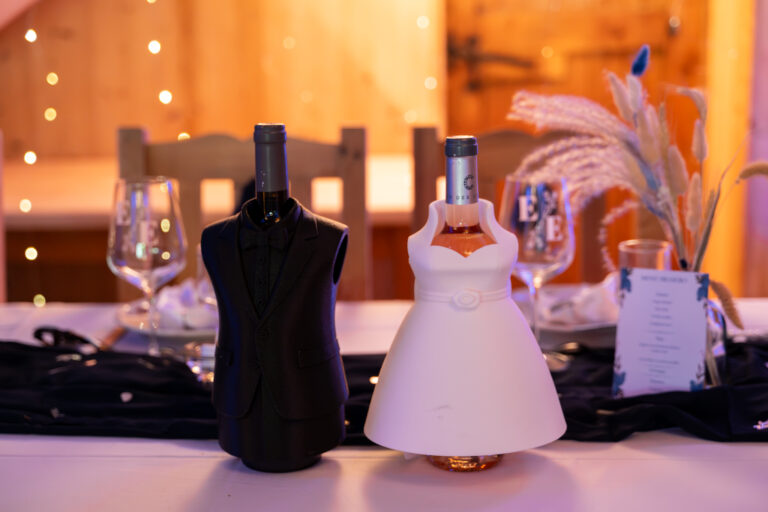 Photographe mariage Jura : tenues miniatures de marié et de mariée sur la table
