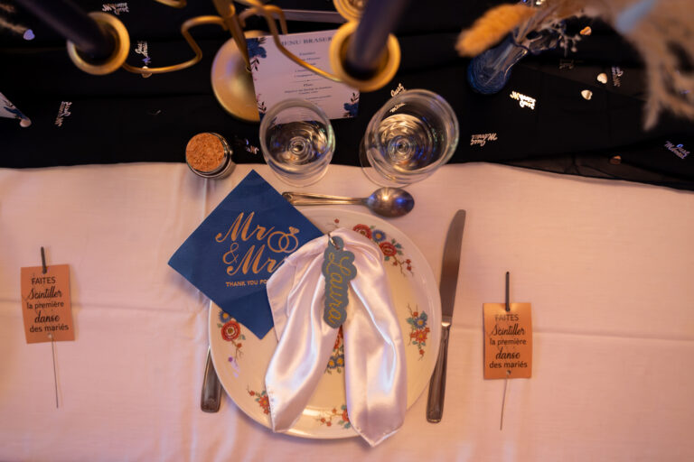 Photographe mariage Jura : table dressée avec marque-place bleu et décoration dorée