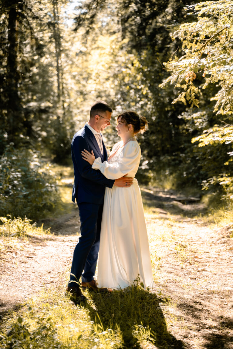 Photographe mariage Jura : mariés main dans la main sur un chemin en sous-bois