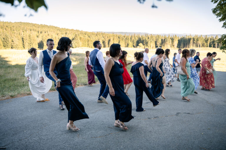 Photographe mariage Jura : invités qui dansent en farandole