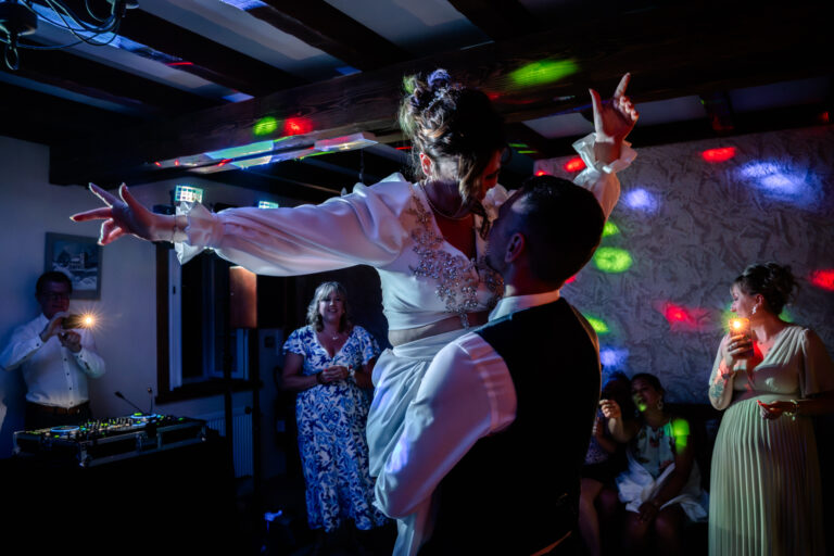 Photographe mariage Jura : mariée portée par les invités sur la piste