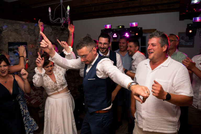 Photographe mariage Jura : invités qui lèvent les bras en dansant