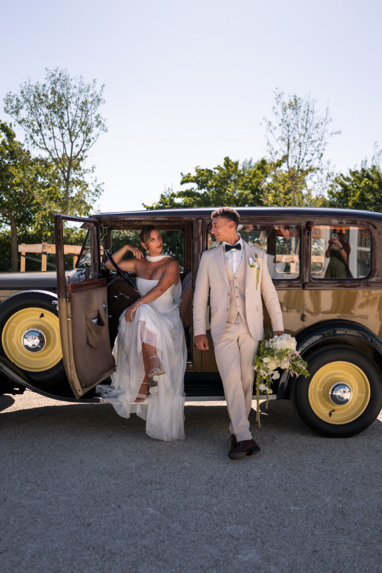 Photographe mariage Jura : mariés devant une voiture de collection décorée de fleurs