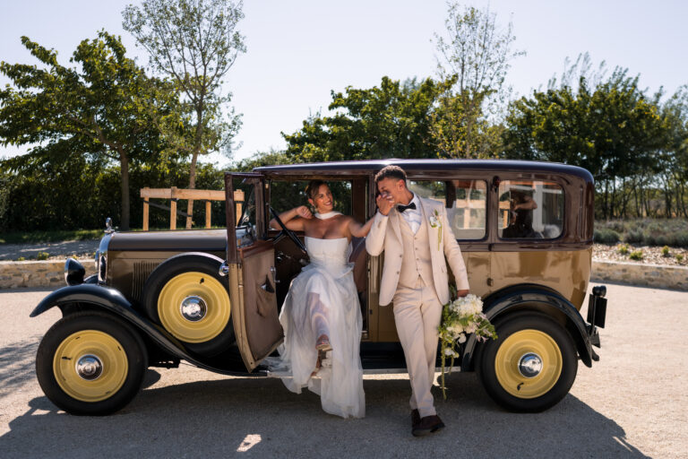 Photographe mariage Jura : mariés qui posent près de leur voiture ancienne