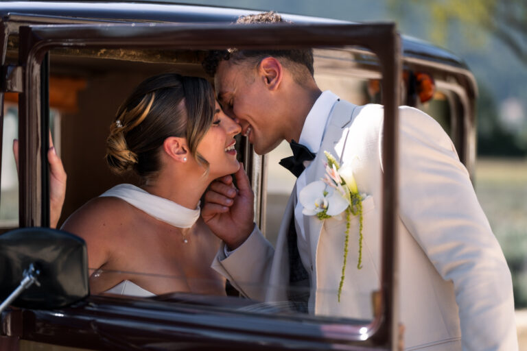 Photographe mariage Jura : mariés qui s’embrassent à la portière d’une voiture de collection