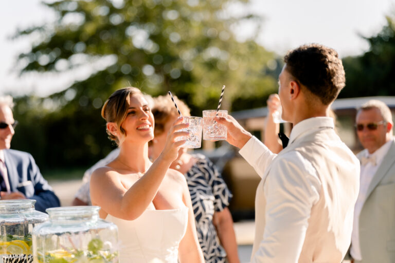Photographe mariage Jura : mariés qui trinquent avec leurs invités en plein air