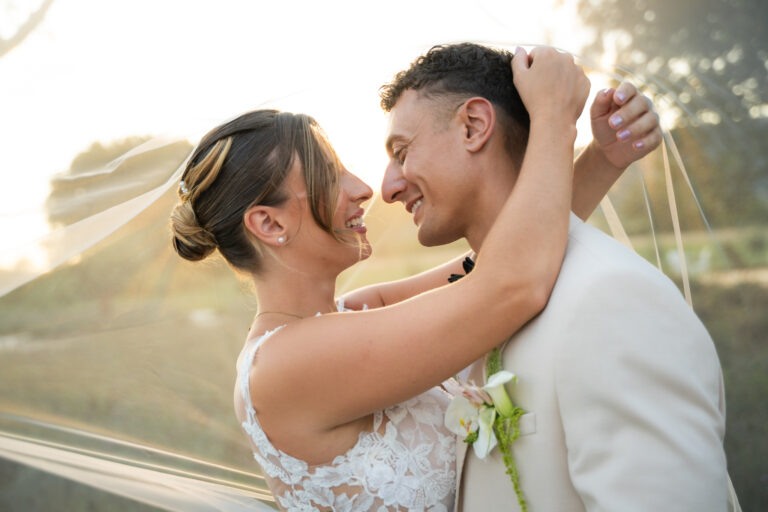 Photographe mariage Jura : mariés nez contre nez sous le voile, dans la lumière du soir