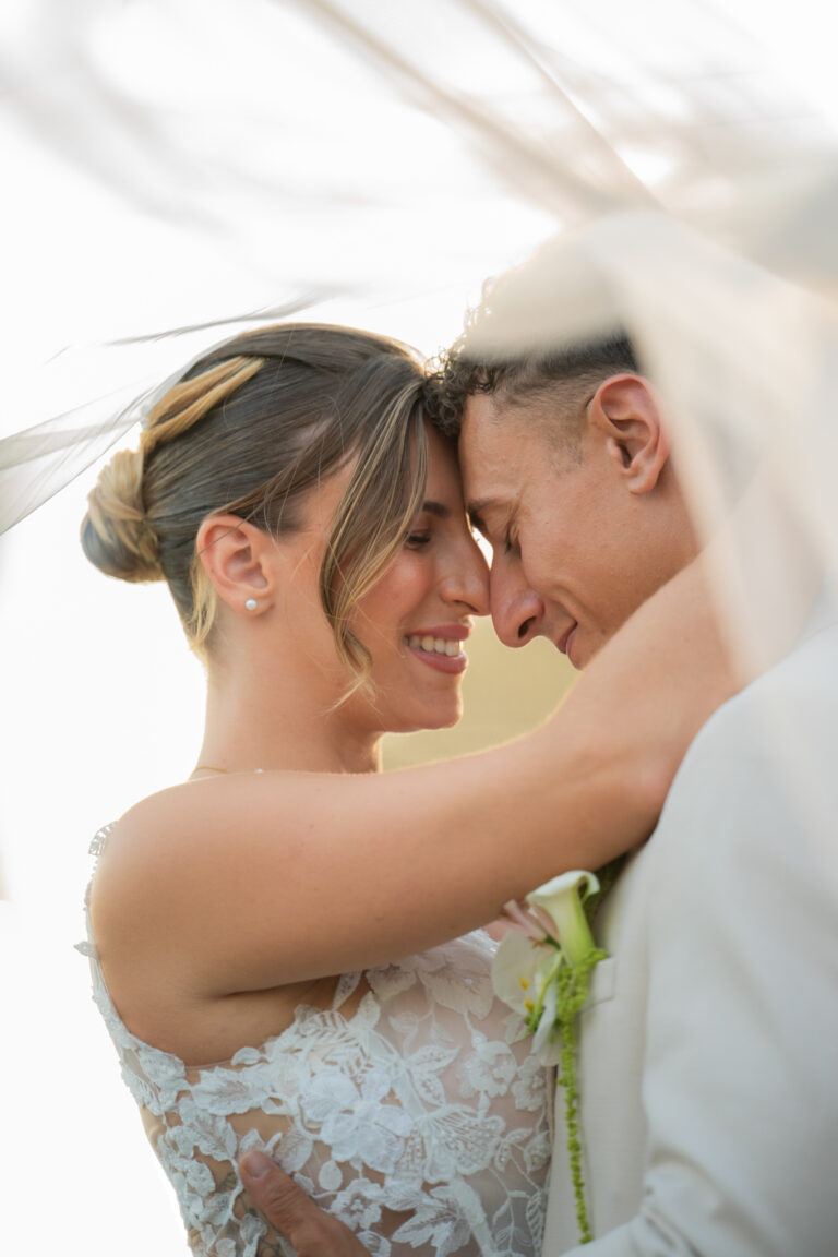 Photographe mariage Jura : mariés front contre front, voile au vent