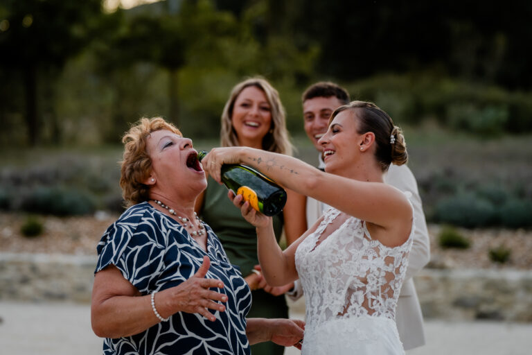 Photographe mariage Jura : invités qui trinquent en riant