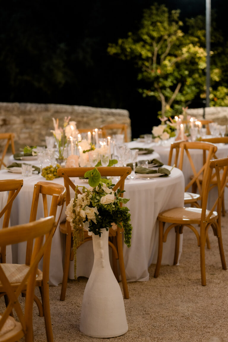 Photographe mariage Jura : tables rondes éclairées le soir dans une cour en pierre