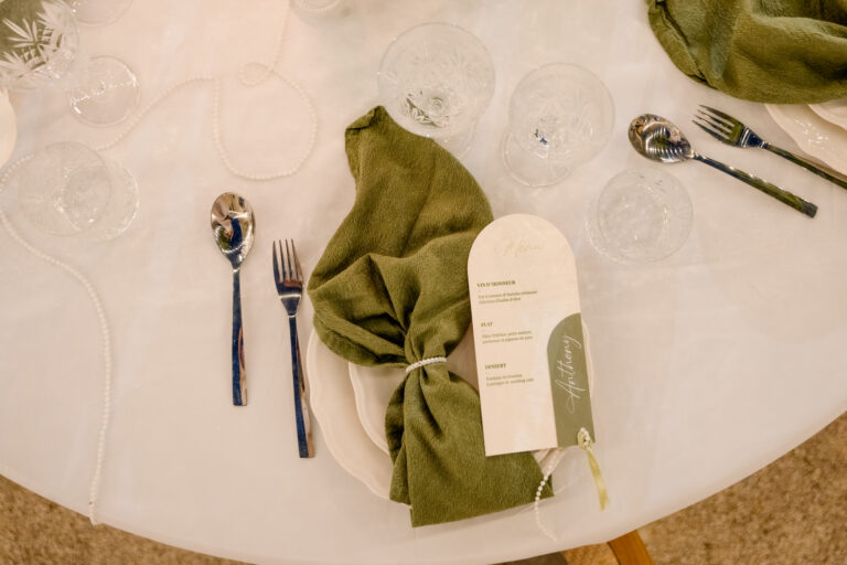 Photographe mariage Jura : serviette vert olive nouée et marque-place sur l’assiette