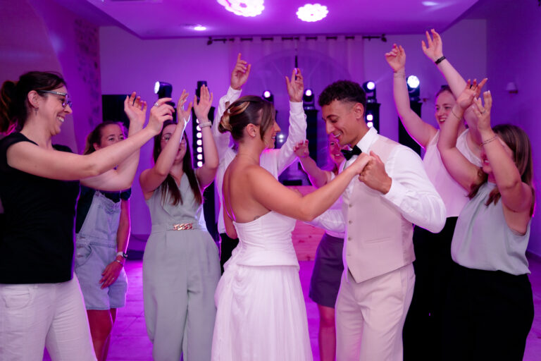Photographe mariage Jura : mariés et invités qui dansent sous les lumières violettes