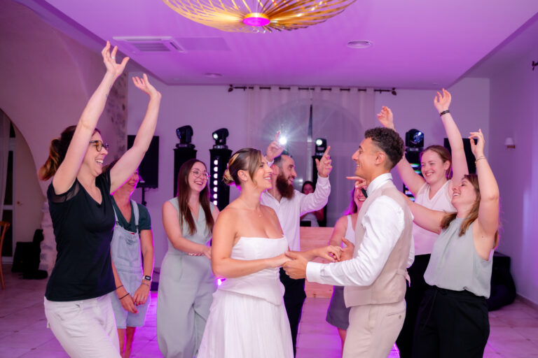 Photographe mariage Jura : invités qui lèvent les bras sur la piste de danse
