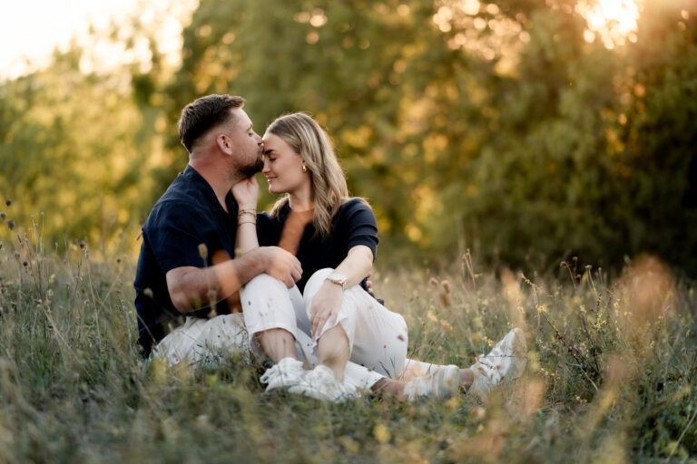 Photographe mariage couple Morez Jura Genève Lausanne Champagnole Lons-le-Saunier Besançon – couple s’embrassant assis dans les herbes hautes