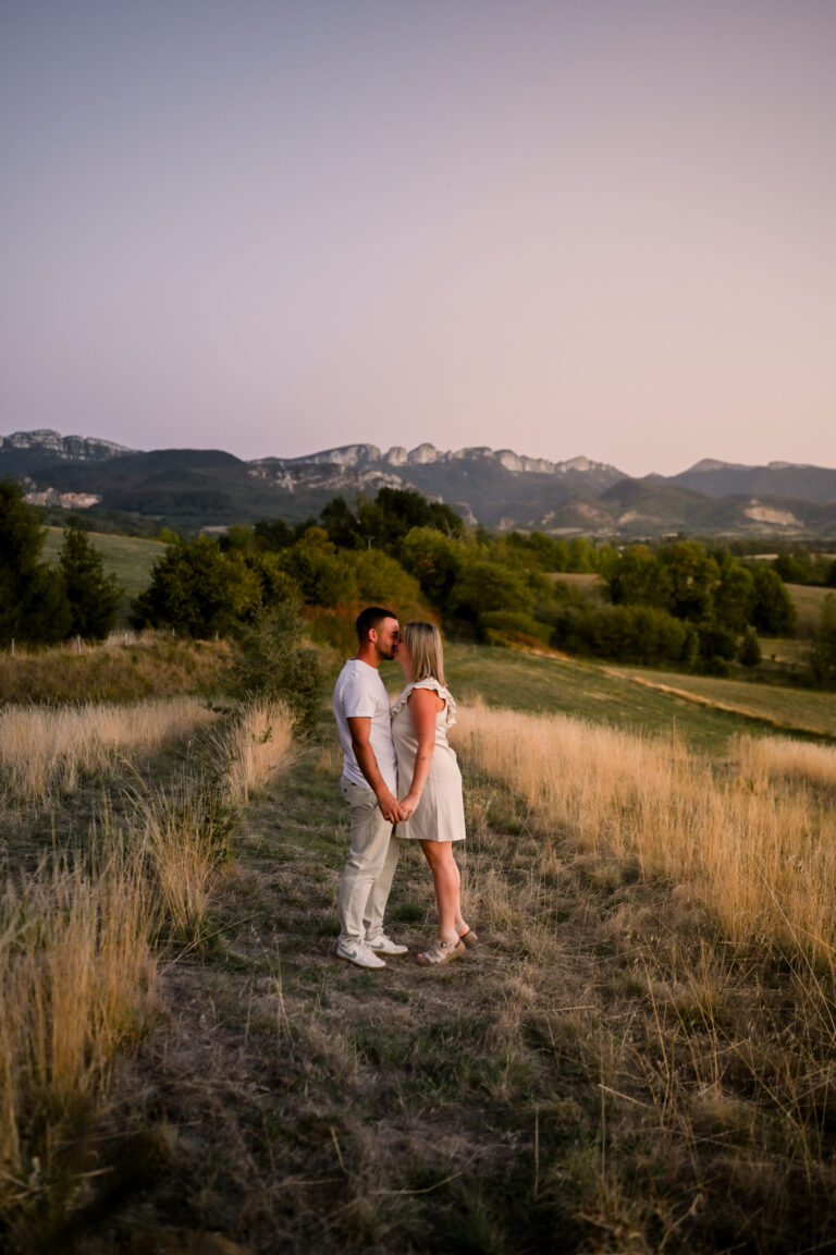Photographe mariage couple Morez Jura Genève Lausanne Champagnole Lons-le-Saunier Besançon – couple se promenant dans un pré au crépuscule