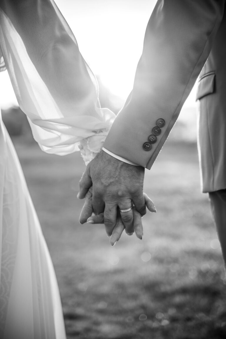 Photographe mariage Jura : mains des mariés enlacées, en noir et blanc