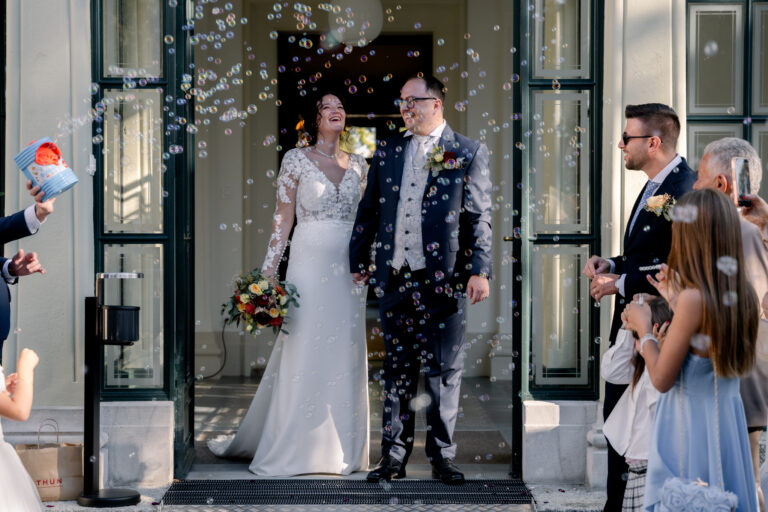 Photographe mariage Jura : sortie des mariés du château, entourés de leurs invités