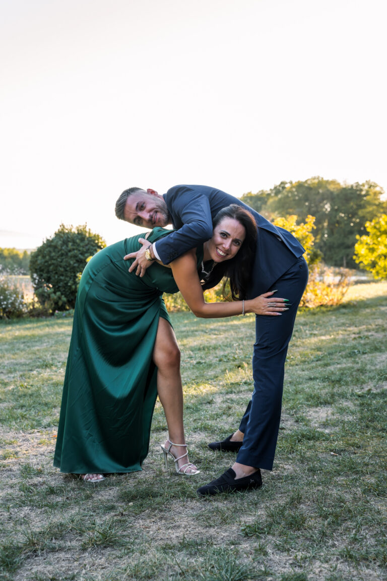 Photographe mariage Jura : invités qui dansent en se penchant en arrière dans l’herbe