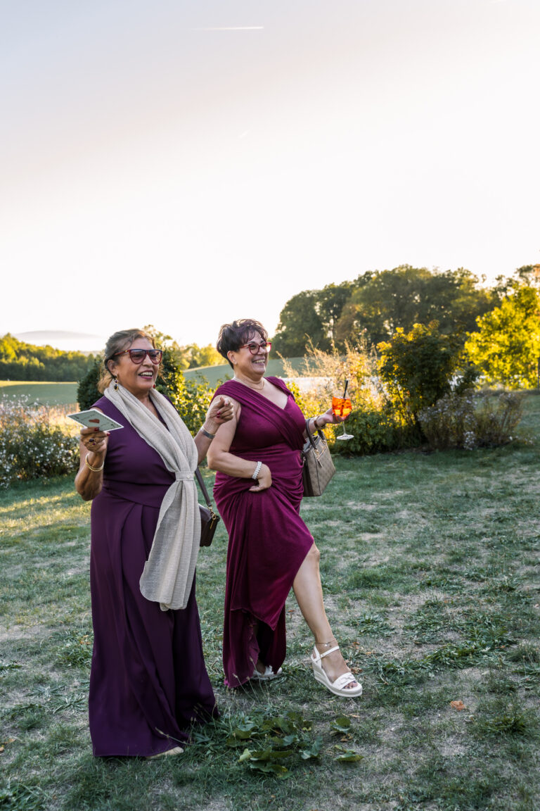 Photographe mariage Jura : invitée en robe violette dans le jardin