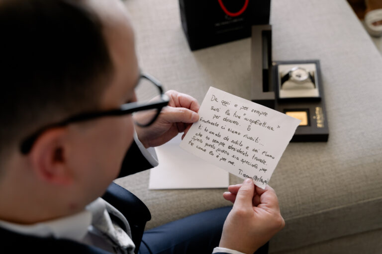 Photographe mariage Jura : marié ému qui lit un petit mot pendant ses préparatifs