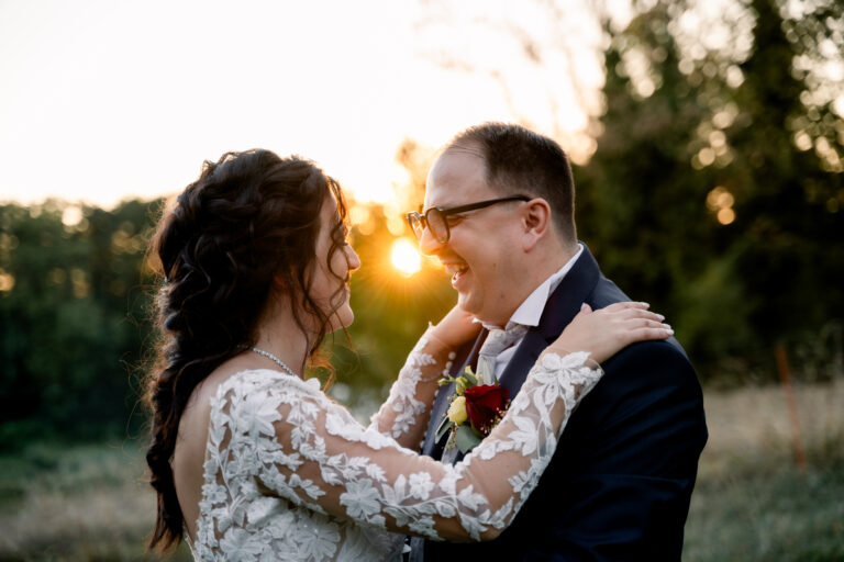 Photographe mariage Jura : mariés complices au soleil couchant, dans un champ