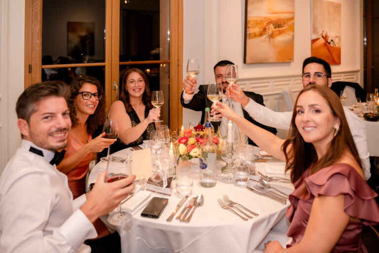 Photographe mariage Jura : invités qui trinquent à table au restaurant
