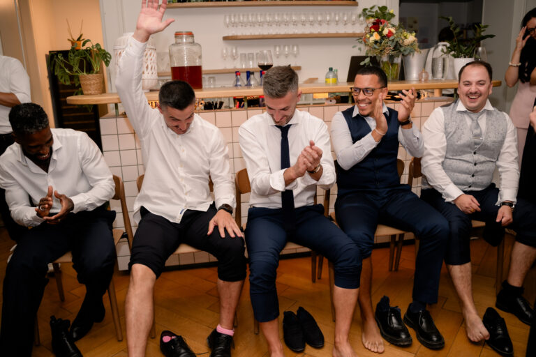 Photographe mariage Jura : invités assis, pieds nus, pour le jeu de la mariée