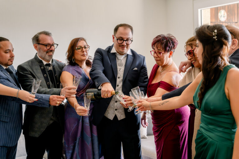 Photographe mariage Jura : marié qui trinque avec ses proches avant le départ