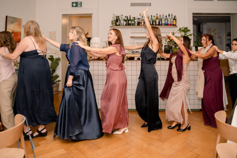 Photographe mariage Jura : invitées qui dansent en robes colorées