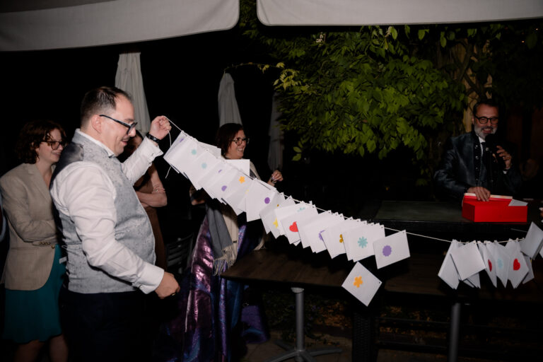 Photographe mariage Jura : marié qui ouvre les enveloppes de la guirlande surprise