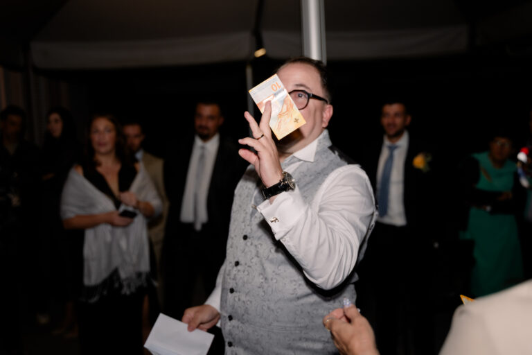 Photographe mariage Jura : marié qui découvre un billet dans une enveloppe