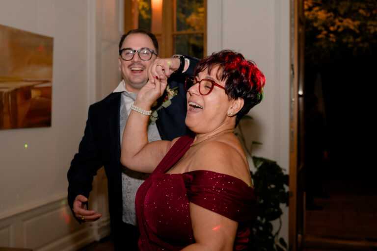 Photographe mariage Jura : invitée en robe rouge qui danse en riant