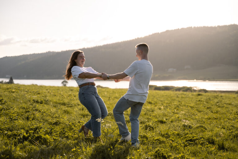 Photographe mariage couple Morez Jura Genève Lausanne Champagnole Lons-le-Saunier Besançon – couple tournoyant dans un pré au bord d’un lac