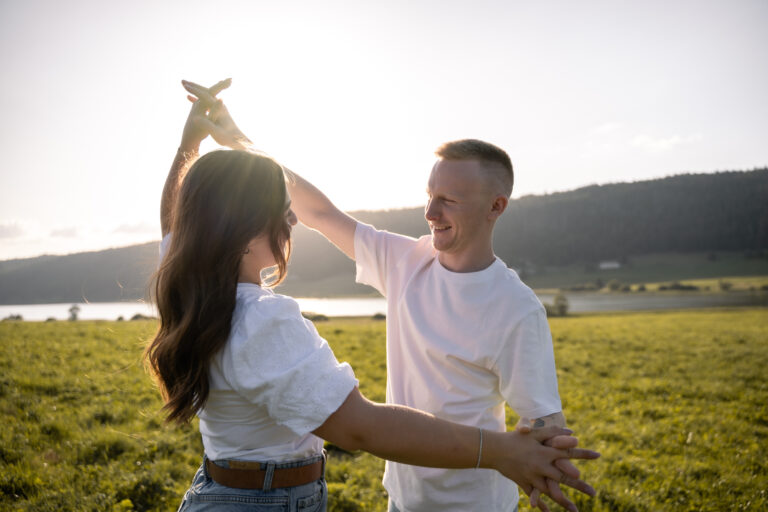 Photographe mariage couple Morez Jura Genève Lausanne Champagnole Lons-le-Saunier Besançon – couple dansant dans un pré au bord d’un lac