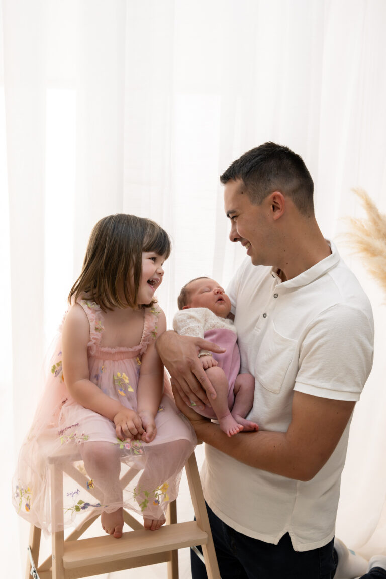 Photographe naissance Jura Pontarlier – papa, grande sœur et bébé