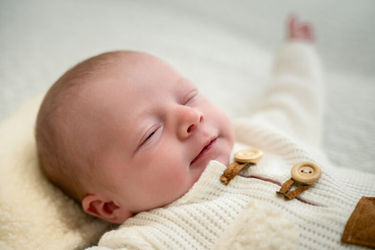 Photographe naissance Jura Morez Les Rousses – nouveau-né souriant en barboteuse tricotée