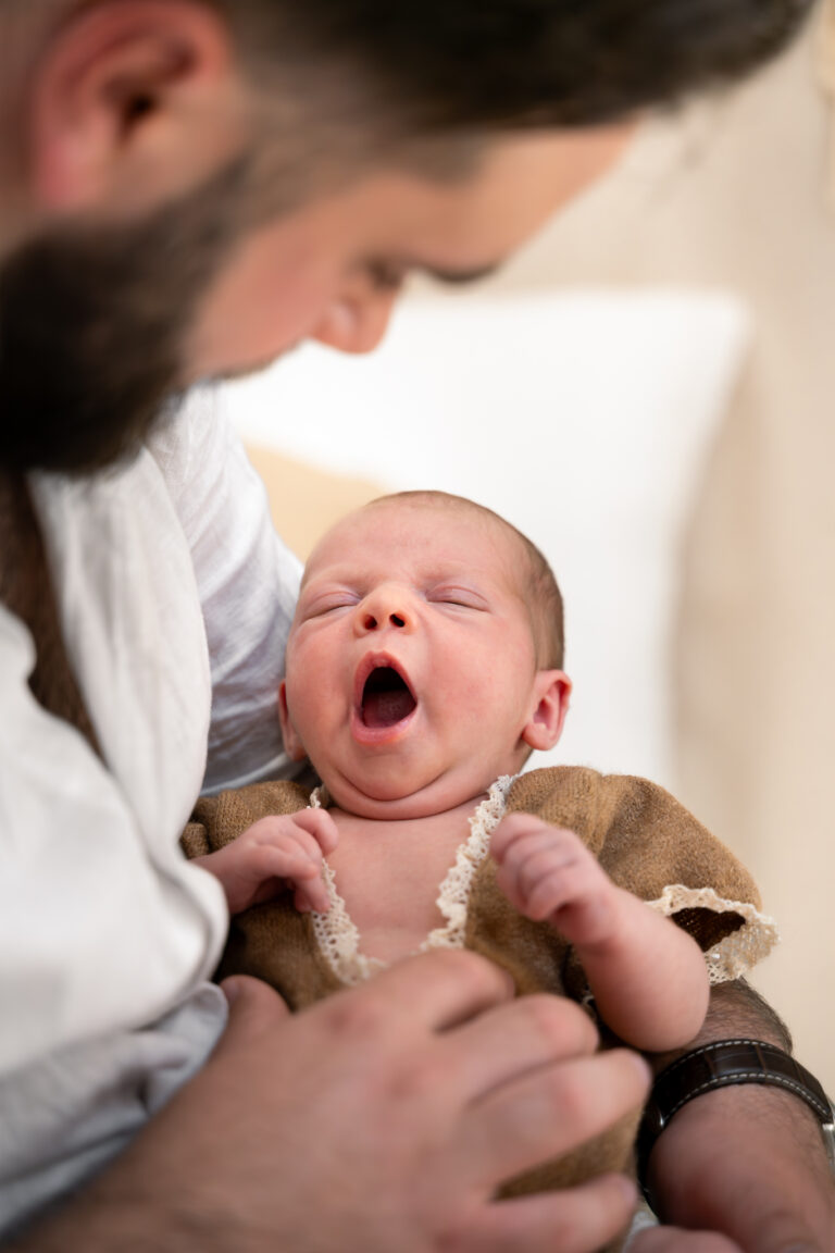 Photographe naissance Jura Morez Champagnole – bébé qui baille dans les bras de son papa